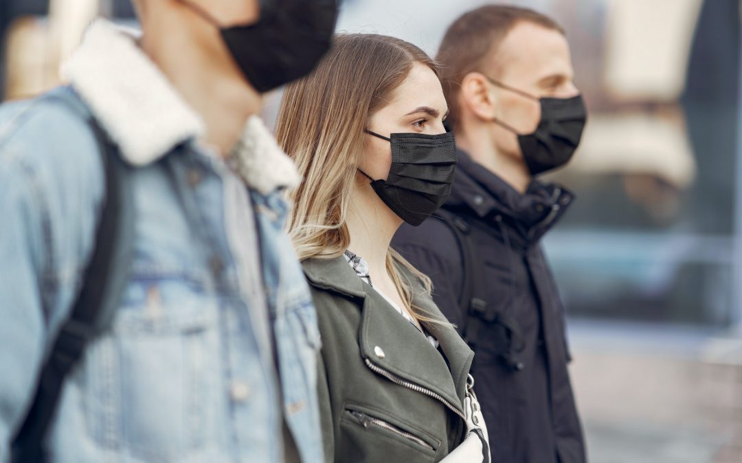 People in a masks stands on the street